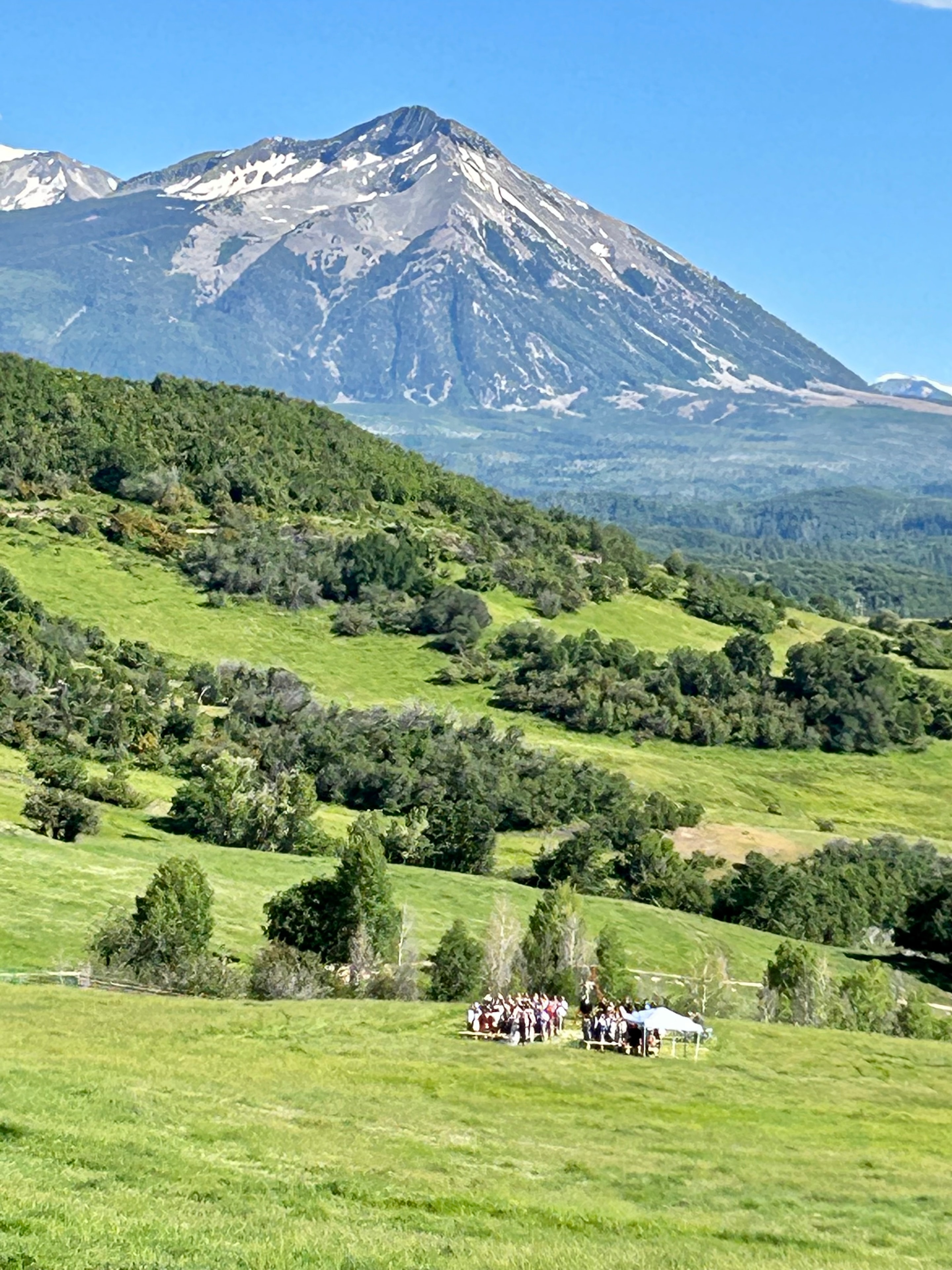 Aerial perspective of the outdoor ceremony in the meadow with Ragged Mountain filling the sky behind the guests