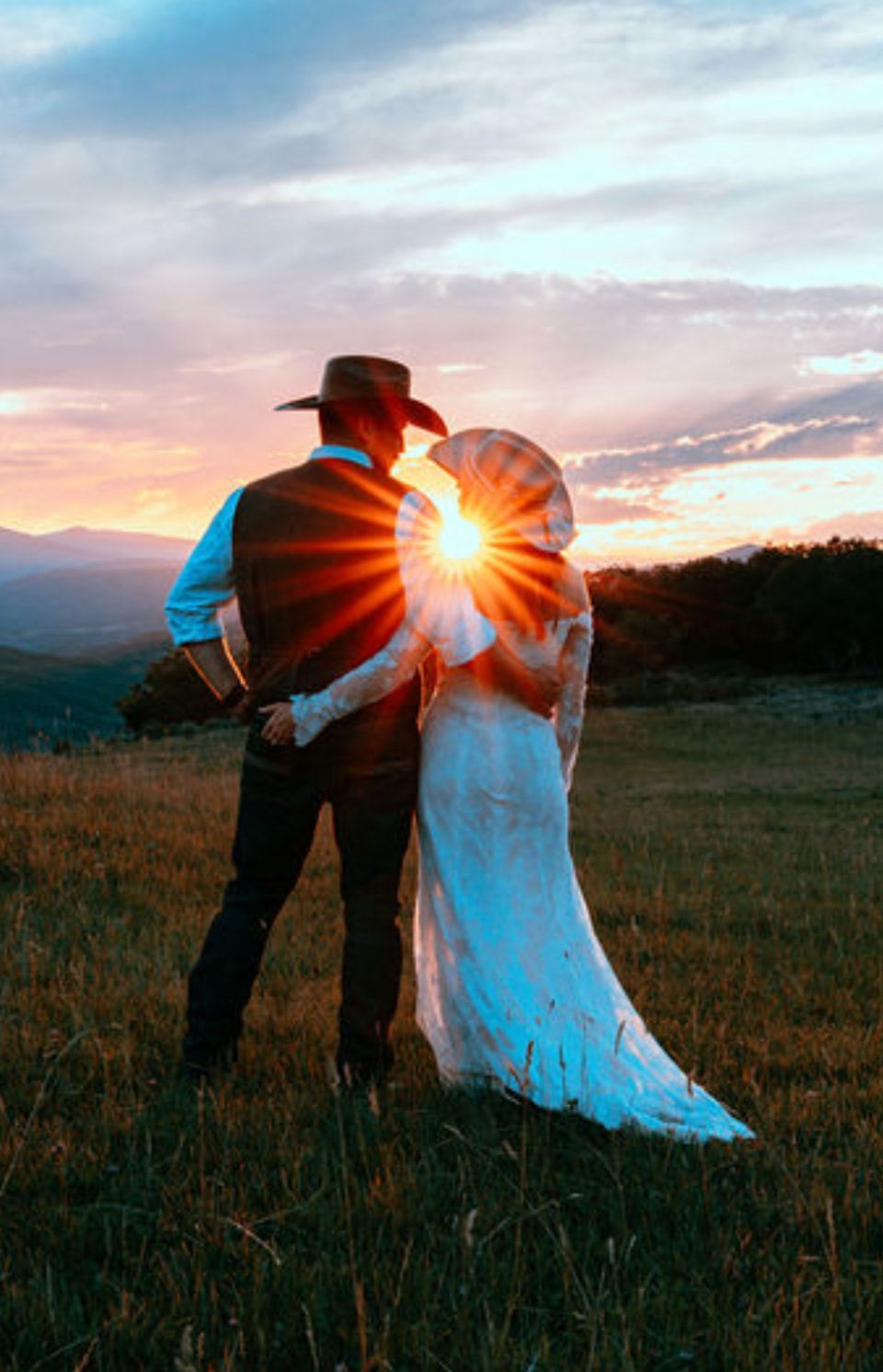 Couple silhouetted at sunset in the mountain meadow