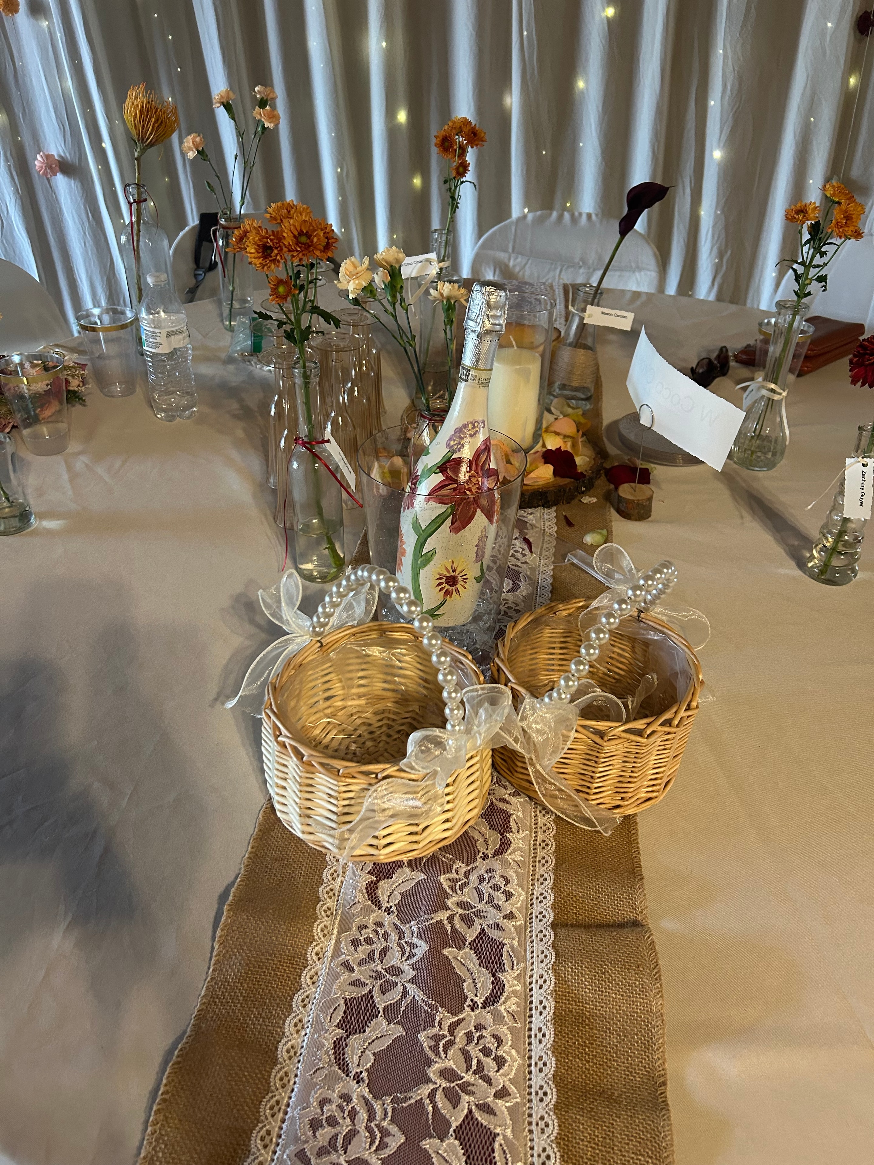 Wedding table styling with flowers, lace runner, and wicker baskets