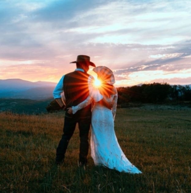 Bride and groom kissing with wildflower bouquet