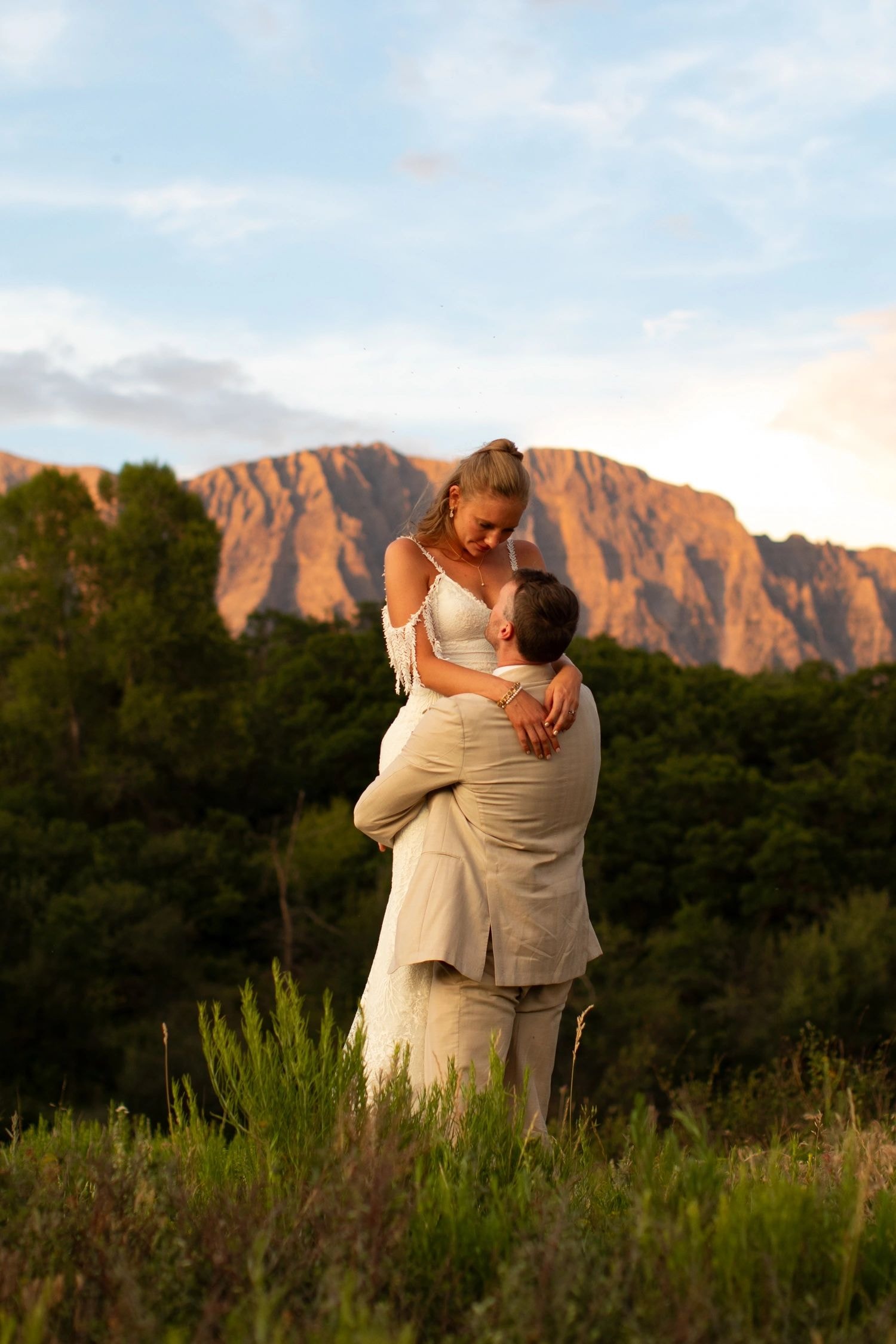 Couple holding hands at sunset mountains